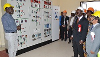 Kingsford Amoako (left), conducting dignitaries round the substation control panel
