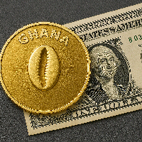 File photo of a cedi coin and dollar note