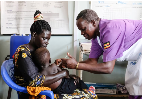 A nurse assistant administers a malaria vaccine to a baby at Apac General Hospital in Uganda