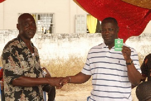 Kofi-Buah receiving his new NDC membership card at a branch meeting