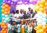 Hollard Ghana cutting ribbon for the opening of Al-Waleed Kindergarten at Nima