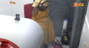 Photo of Madam Louisa Enyonam, operating her phone with her leg