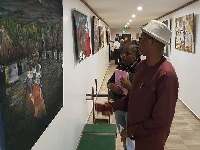Mr. Lamptey explaining a point to the reporter on the painting