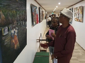 Mr. Lamptey explaining a point to the reporter on the painting