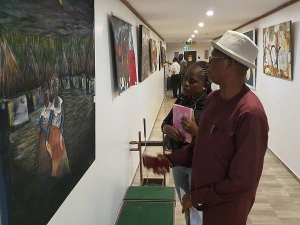 Mr. Lamptey explaining a point to the reporter on the painting