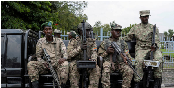 M23 rebels sit on a truck during the escort of captured FDLR members (not pictured) to Rwanda