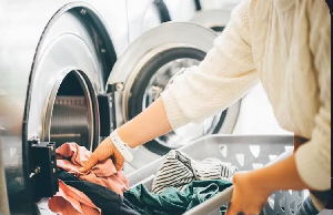 File photo of person loading clothes into a washing machine