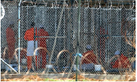 Detainees from Afghanistan sit in their cells at Camp X-Ray at the US military base in Guantanamo