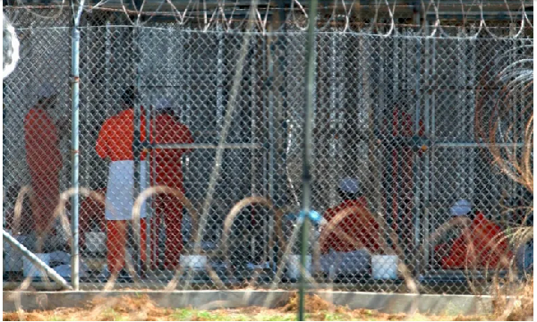 Detainees from Afghanistan sit in their cells at Camp X-Ray at the US military base in Guantanamo