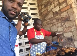 Raymond Danqua busily grilling pork for sale
