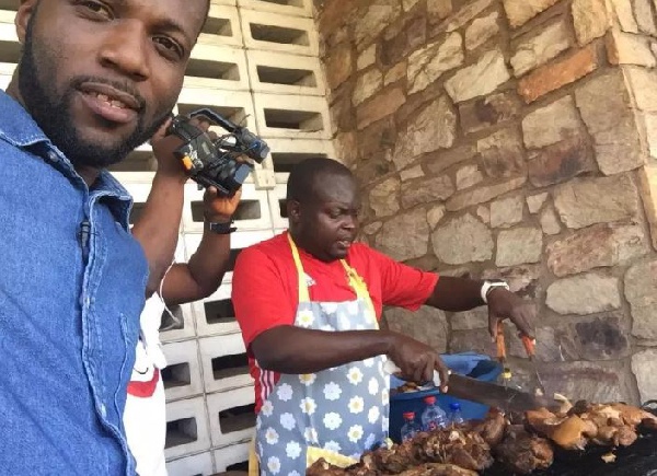 Raymond Danqua busily grilling pork for sale