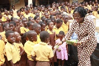A representative from the Foundation distributing chocolate to the school children