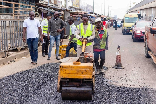 Kasoa MCE operating the roller to get the potholes fixed