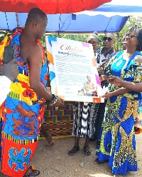 Nana Kwaku Budu Akomeah V receiving the citation from Madam Gertrude Agbenaza