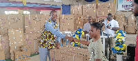 Ellembelle DCE presenting items to some PWDs