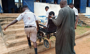 One of the siblings being assisted in the wheel chair