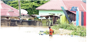 A man wades in waist-deep water in Boko, Dar es Salaam,  following two days of  ceaseless rain