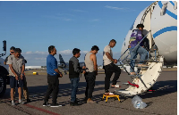 Immigrants board a plane to be deported from the US by Immigration and Customs Enforcement officers
