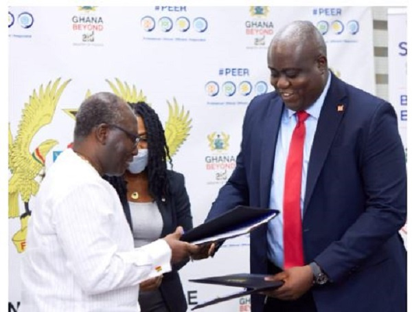 Ken Ofori-Atta presents signed document to James Bruce