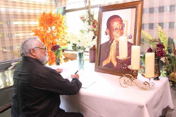 Former President Jerry John Rawlings signing the book of condolence for the late Kwabena Adjei